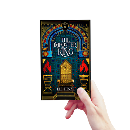 A hand holding up a paperback of the ancient fantasy book The Imposter King by Eli Hinze