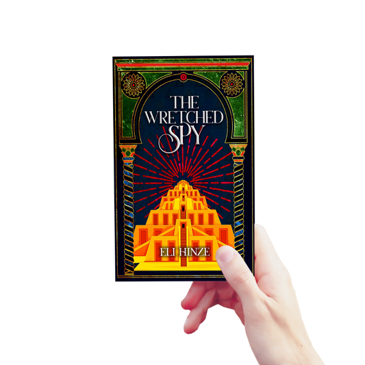 A hand holding up a paperback of the ancient fantasy book The Wretched Spy by Eli Hinze